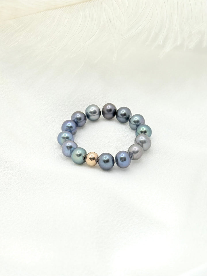 Mina Peacock Ring aus schimmernden Peacock-Süßwasserperlen auf hellem Stoff arrangiert – eleganter handgefertigter Ring.