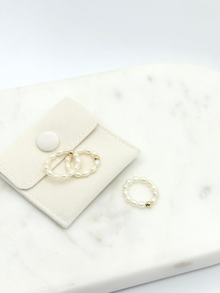 Mehrere Sina Perlenringe auf Marmorplatte arrangiert