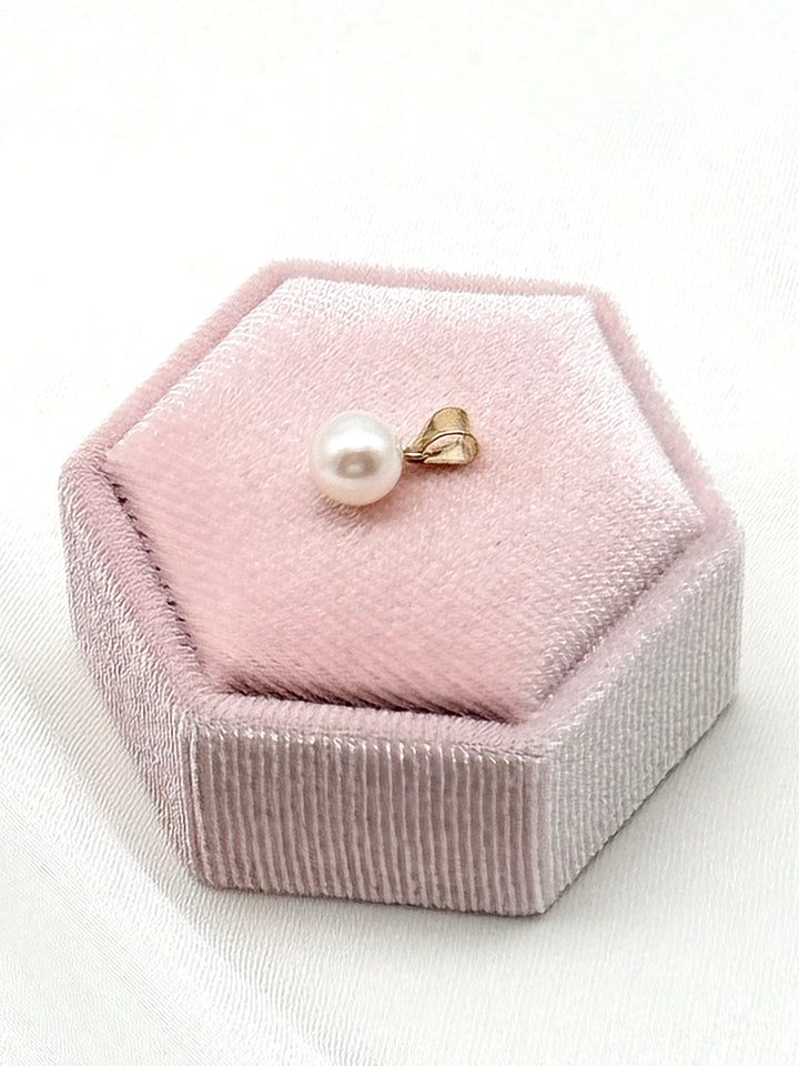 Seitenaufnahme des Akoya Pearl Pendant mit 14k Goldöse auf rosafarbener Samt-Schmuckbox gelegt
